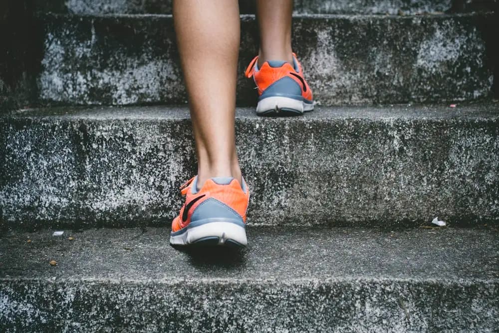 Piernas de una persona corriendo escaleras arriba